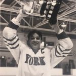An old photo of a female hockey player holding a trophy