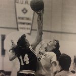 An old photo of female basketball players reaching for the ball