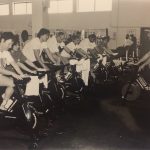 An old photo of students doing indoor cycling workout