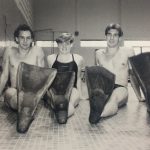 An old photo of five swimmers wearing swim fins