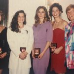 A photo of women at a banquet with their awards