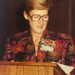 A woman speaking behind a lectern
