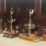 A photo of an array of trophies atop a table