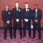 A photo of four male athletes at a banquet