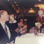 A man drinking at a table at a banquet
