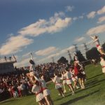 A photo of cheerleaders performing in a field