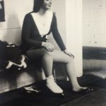 An old photo of a figure skater putting their skate on
