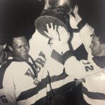 An old photo of two hockey players holding a trophy