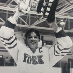 An old photo of a male hockey player holding a trophy