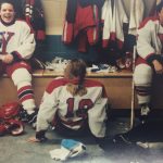 A photo of three female hockey players in a lockerroom