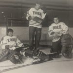 An old photo of three York hockey players reading their manuals