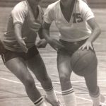An old photo of two female basketball players playing in the court