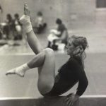 An old photo of a female gymnast practicing on a balance beam