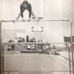 An old photo of a female gymnast practicing on poles