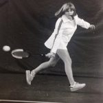 An old photo of a female tennis player hitting back a ball