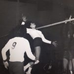 An old photo of a female volleyball player jumping to hit back a ball
