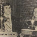 An old photo of a man and a woman holding their trophies