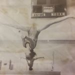 An old photo of a female gymnast practicing on a balance beam