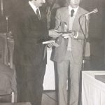 An old photo of a man receiving an award