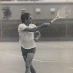 An old photo of a man with a tennis racket hitting back a ball