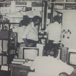 An old photo of men operating machines in a room