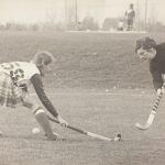 An old photo of two field hockey players on a field