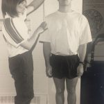 An old photo of a man getting his height measured