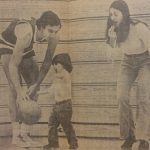 An old photo of a male basketball athlete and a woman playing around with a child