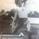 An old photo of a female athlete making a jump in track and field