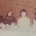 An old photo of faculty members sitting at a table at a banquet
