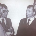 An old photo of men in suits having a conversation