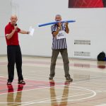 The head referee demonstrating an activity to students about to throw a noodle stick