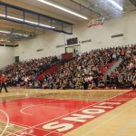 Wide shot of students in the indoor gym seating