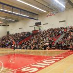 Wide shot of students in the indoor gym seating