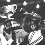 An old photo of a male hockey player holding a trophy at 1986 Champs