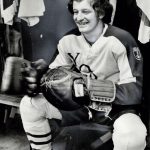 An old photo of a hockey player smiling at the camera