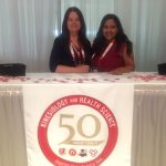 A photo of two girls sitting behind the 50th anniversary table